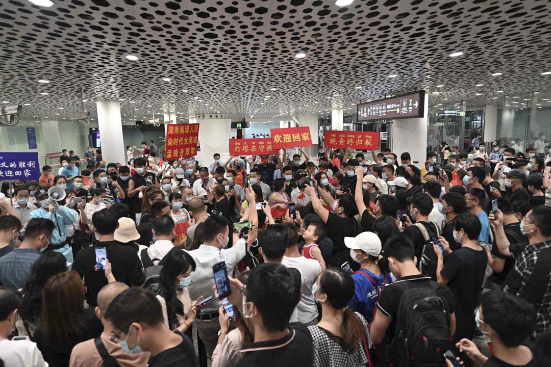 2021年9月25日，人們在深圳寶安國際機場等待華為首席財務官孟晚舟時，舉著寫有歡迎的橫幅和標語牌。