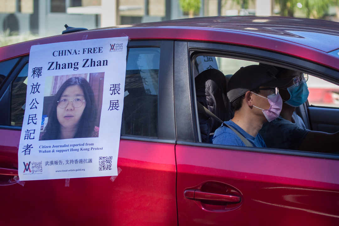 2020年11月15日，美國加州帕薩迪納（Pasadena），一輛汽車跟在疫情送葬車隊後，貼海報呼籲釋放中國公民記者張展。攝：Allen J. Schaben/Getty Images