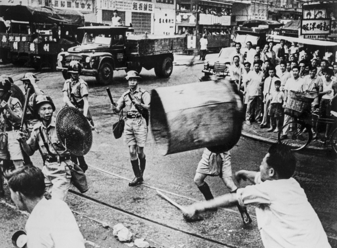 1967年6月,六七暴動期間,一名男子在街頭向警察扔垃圾桶。