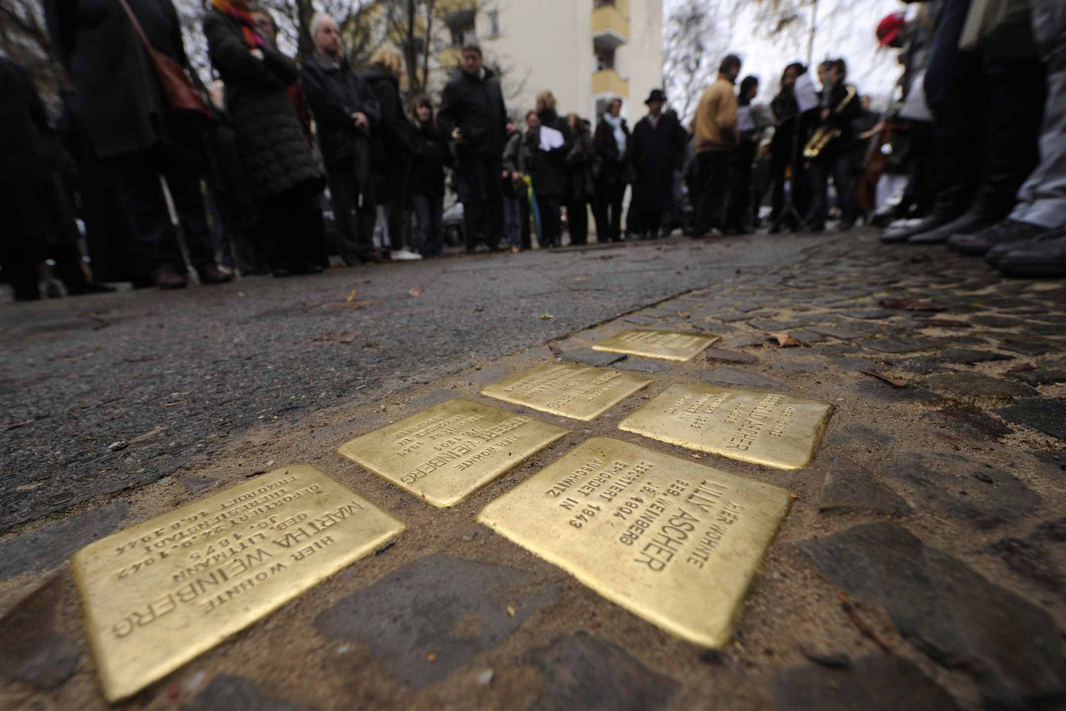 2008年11月26日柏林克罗伊茨贝格区,人们站在“绊脚石”(Stolpersteine)周围。
