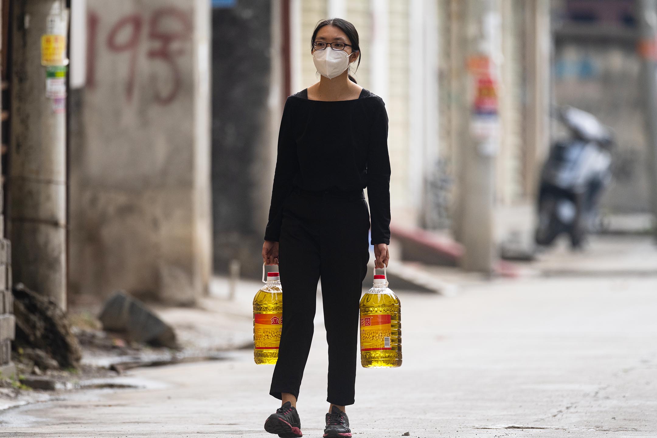 2021年4月19日中國雲南省瑞麗市,一名志願者攜為村民購買食用油。
