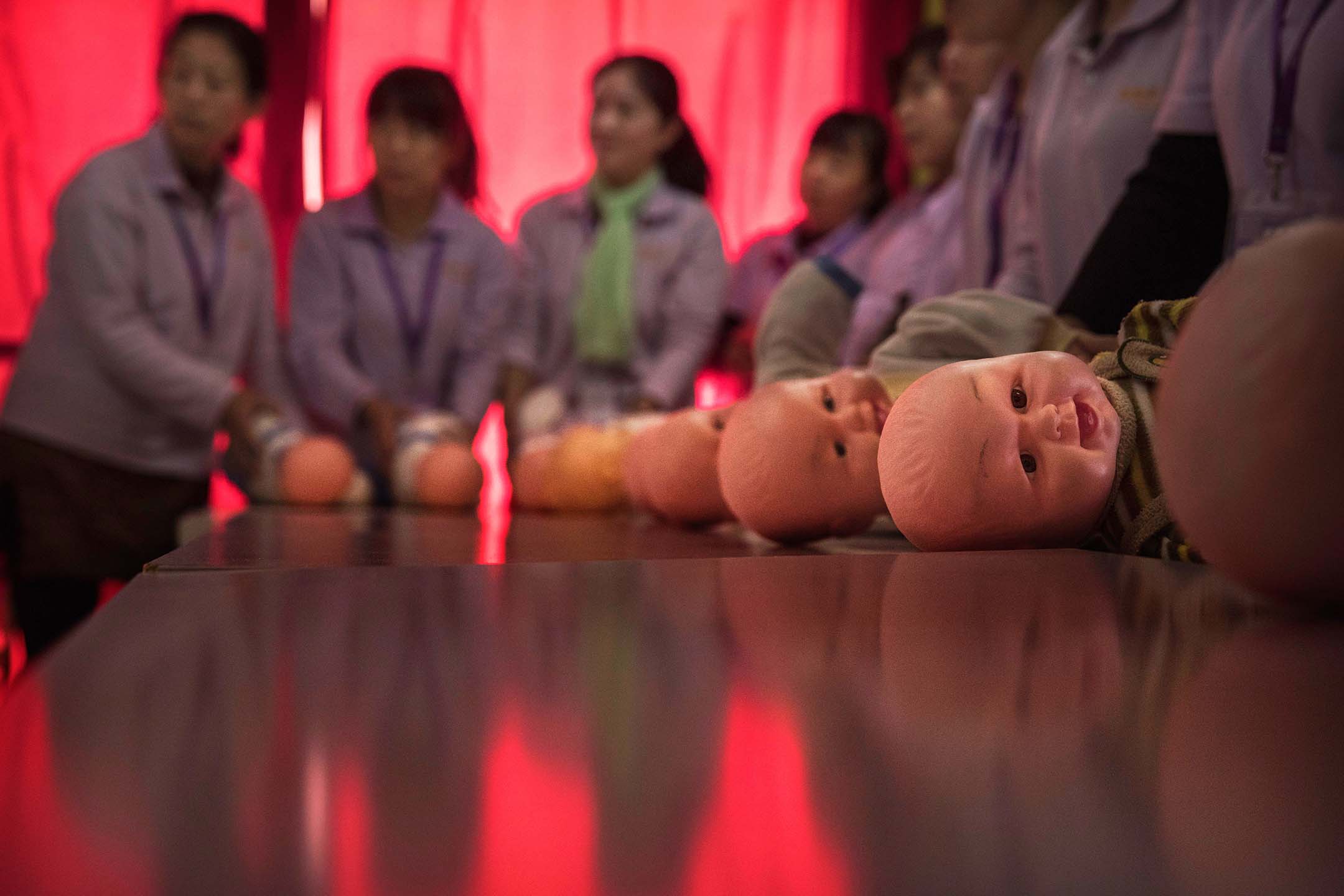 2016年10月28日中国北京,当中国妇女接受培训成为合格的保姆时,塑料婴儿放在桌子上。