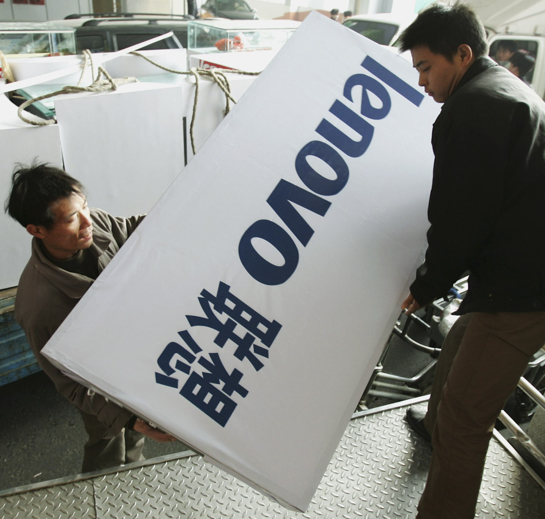 2004年12月8日,北京的一個電腦市場,工作人員拿著聯想電腦的海報。