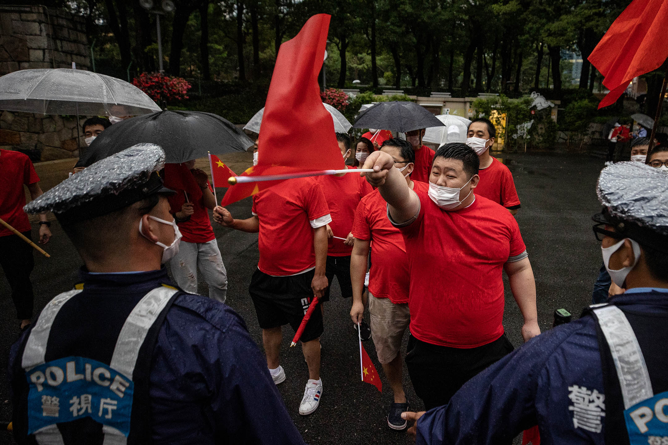 2021年7月1日日本东京,警察站在新宿中央公园的中国共产党的支持者前。