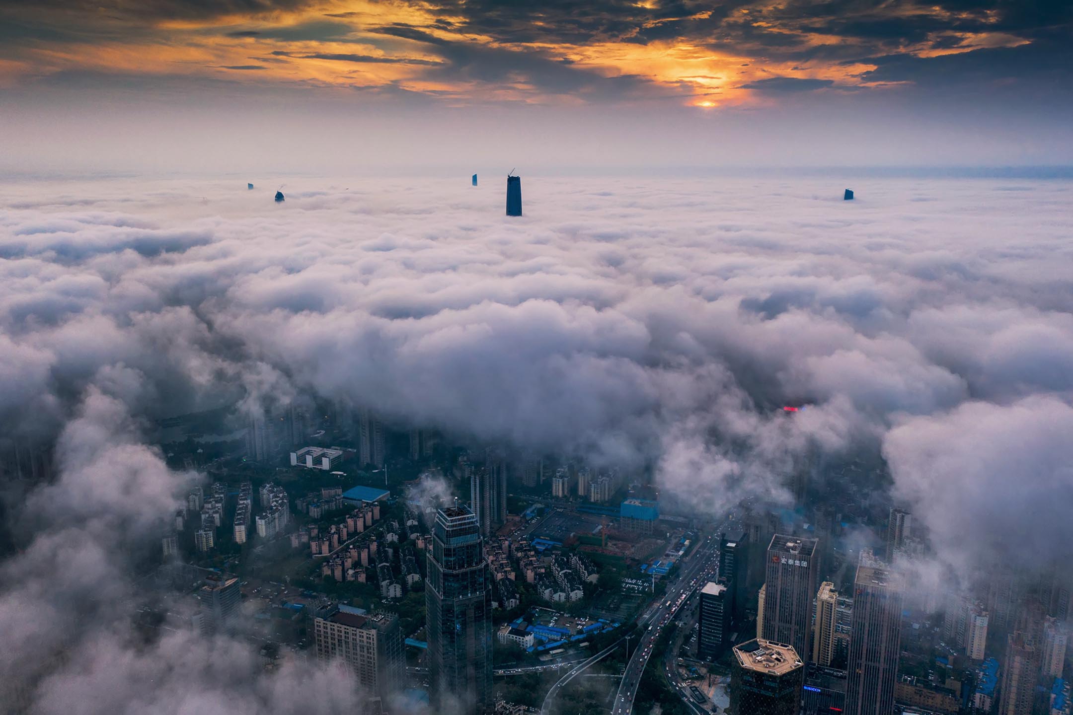 2021年6月5日中国湖北省武汉市下雨后,摩天大楼被厚厚的云层包围。