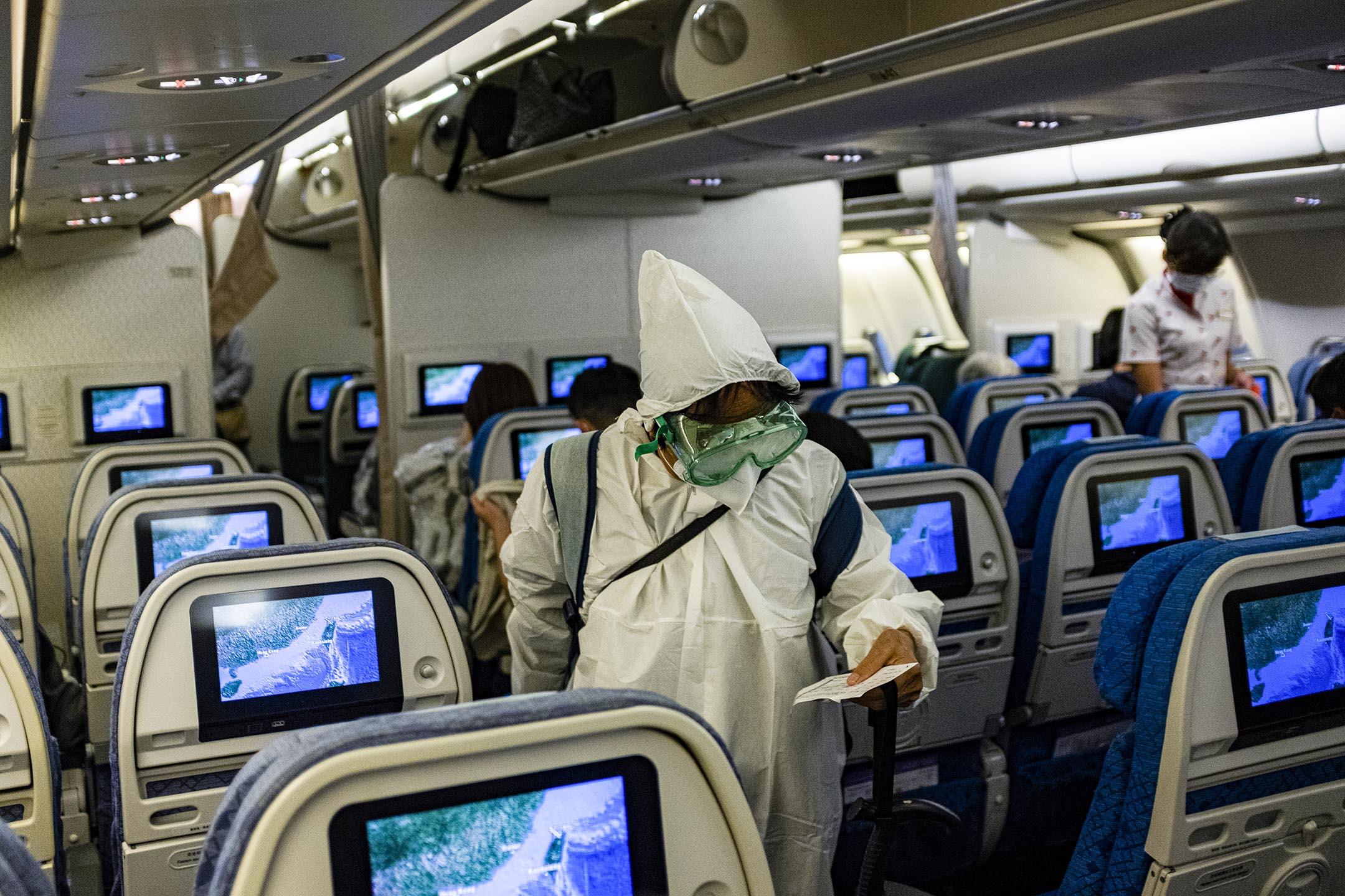 2020年4月27日桃園國際機場，一班飛往香港的飛機，一名旅客穿上保護衣。