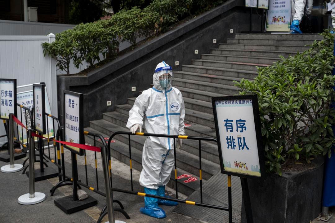 深圳福田區一間隔離酒店外,穿上保護衣的工作人員安排旅客入住。