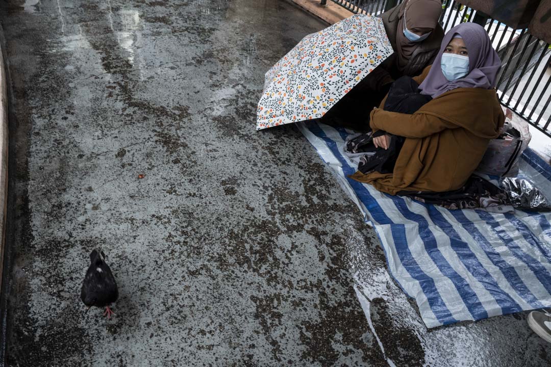 2022年2月20日,两位移工于严寒又下雨的情况之下,在铜锣湾的天桥上休息。