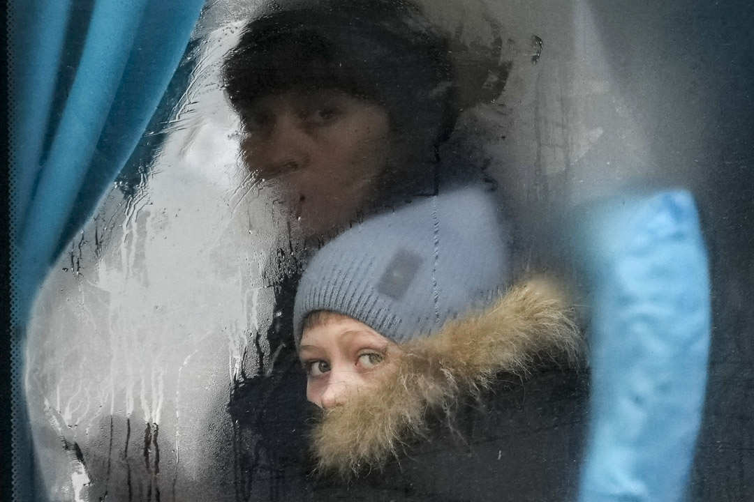 2022年2月24日,一名女士和女童坐車離開烏克蘭東部的盧甘斯克地區,二人凝視著窗外。攝:Vadim Ghirda/AP/達志影像
