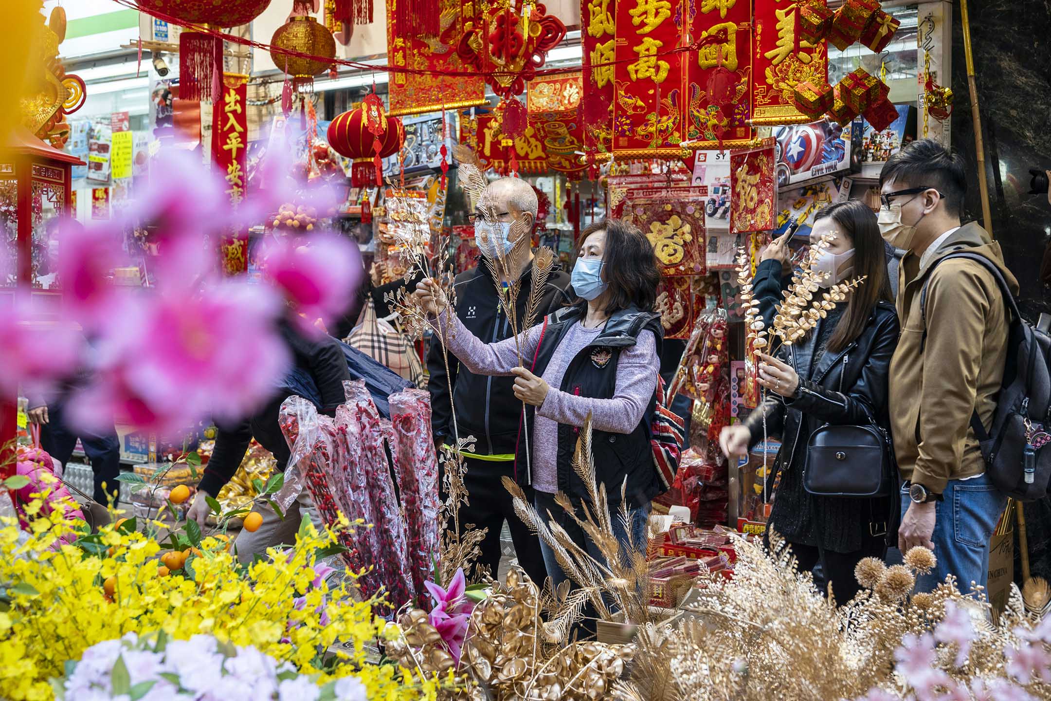 2022年1月30日,市民在香港的一个摊档观看鲜花和农历新年装饰品。