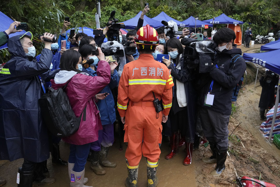 2022年3月24日,中國西南部廣西省莫埌村,一名救援隊成員在墜機現場向媒體介紹情況。