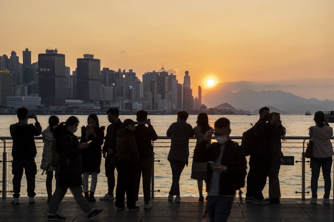 2022年2月23日,尖沙咀的市民欣赏日落。