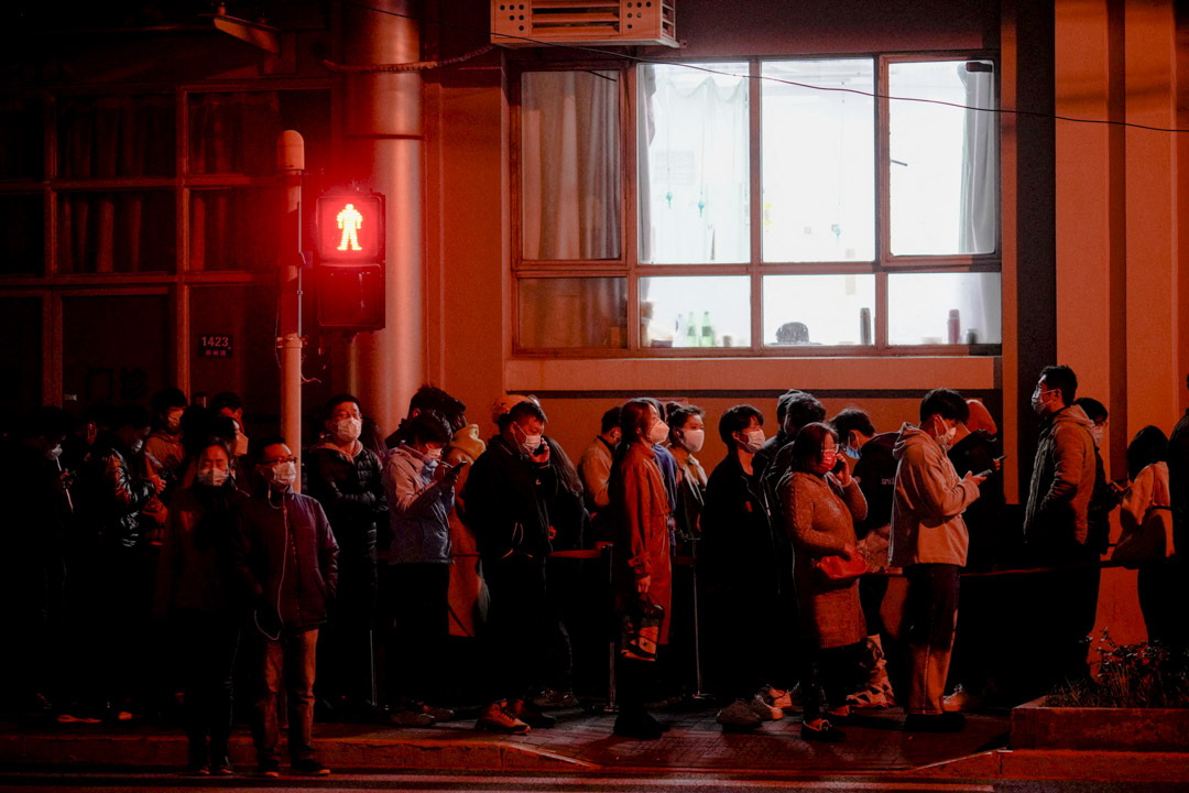2022年3月27日,上海疫情期間,人們在醫院外的核酸檢測站附近排隊等待檢測。
