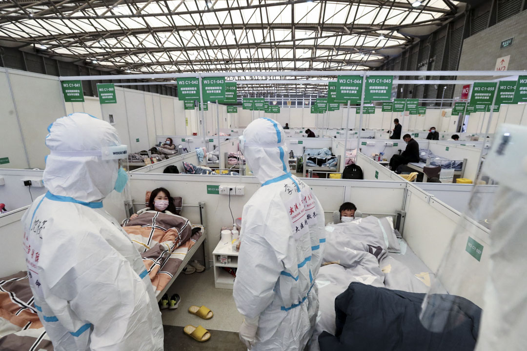 2022年4月9日,上海,身著防護衣的醫護人員在展覧館改建而成的臨時醫院查房。
