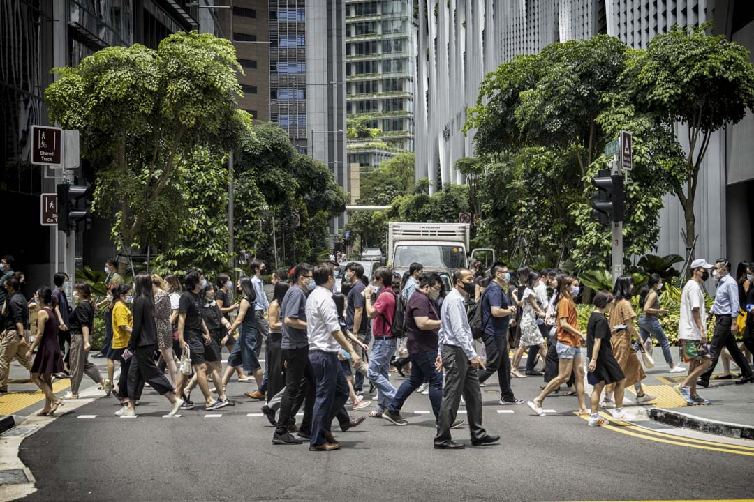 2022年4月26日,新加坡中央商务区的行人在过马路。