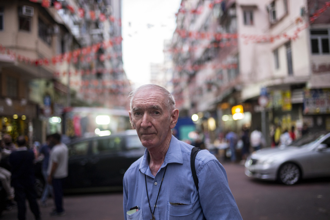 12年前,75歲的獻主會神父胡頌恆(John Wotherspoon)搬入油麻地劏房居住。近年疫情爆發,他見證廟街人們在經濟低迷中的掙扎。