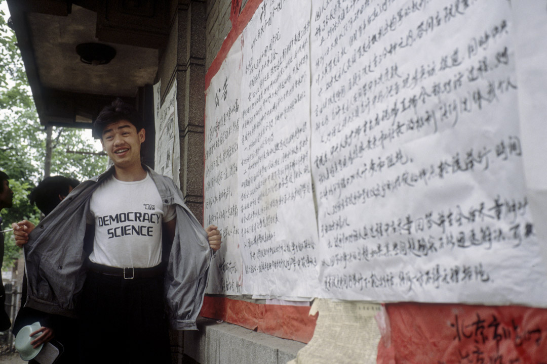 1989年5月11日,北京大學民主牆,吾爾開希展示寫著「民主科學」的襯衫。