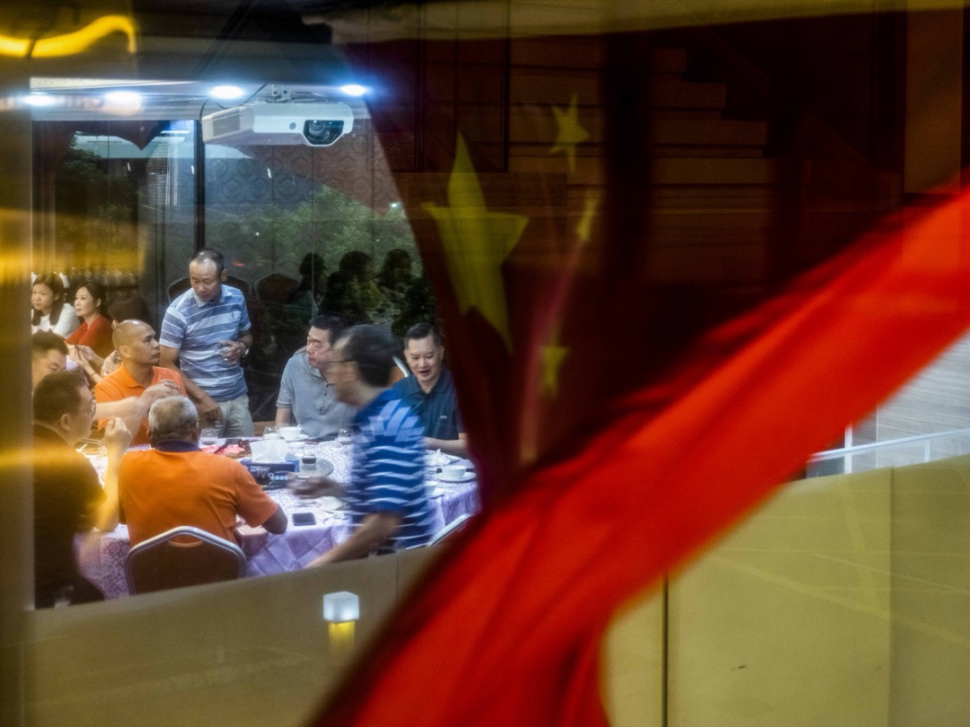 2022年6月26日,食客在尖东一间酒楼晚宴,窗外有一幅国旗在风中飘扬。