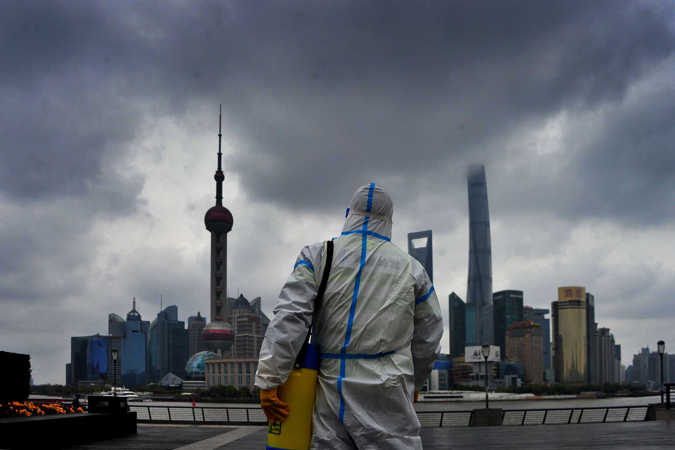 2022年3月31日,上海,一名身穿防護衣的工人在上海的外灘進行消毒。