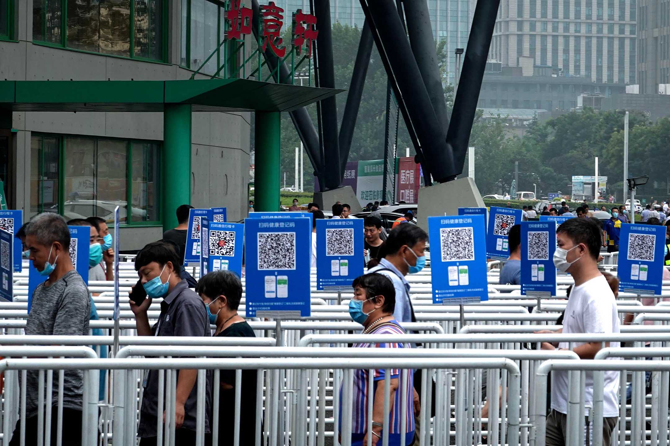 2020年8月5日,鄭州,鄭州食品博覽會上,戴著口罩的人們排隊接受體溫檢測。