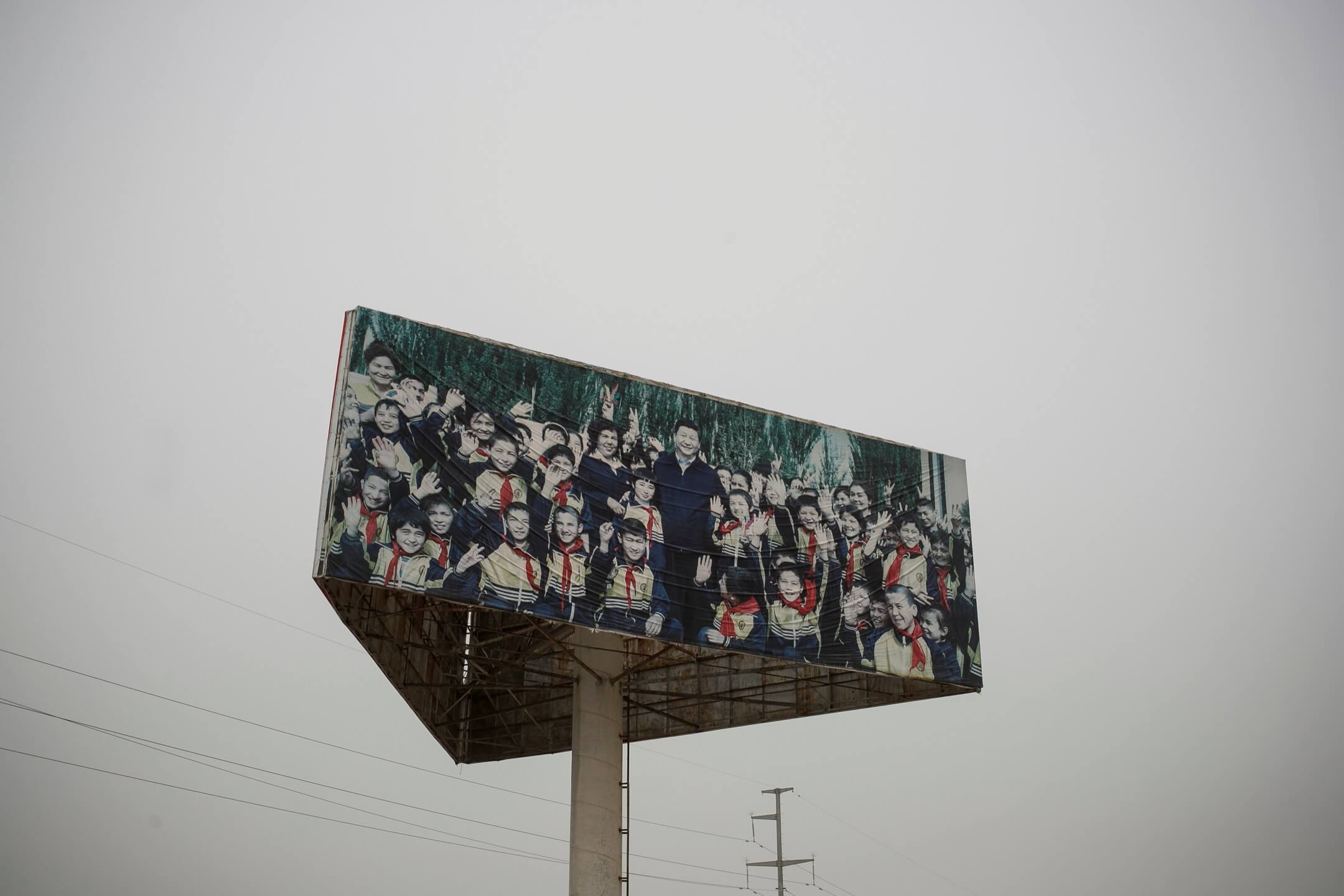 2021年5月3日,新疆喀什地区一个监狱外,一块大型广告版展示著一副中国国家主席习近平与学生的合照。