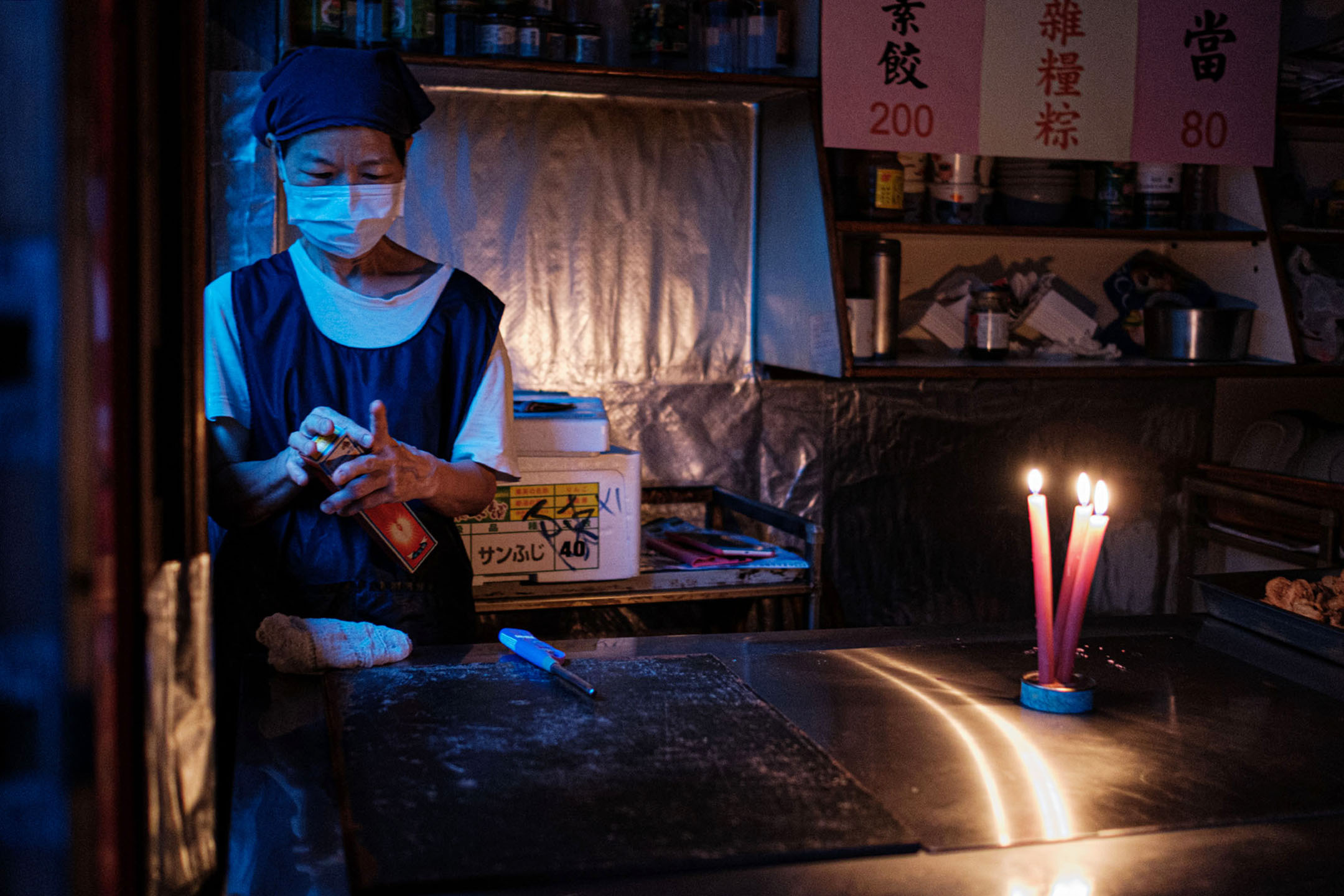 2021年5月13日台北,停电期间食店内一名职员点起蜡烛。