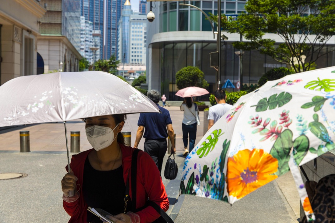 2022年7月14日,中國上海,市民用傘遮擋太陽光。
