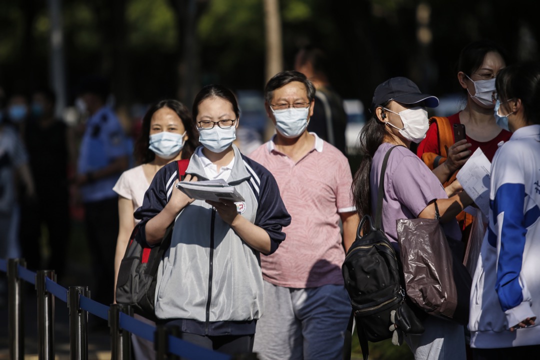 2020年7月,中国首都北京,家长陪同子女前往高考考场。