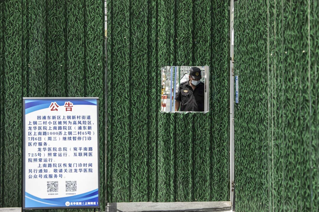 2022年7月6日,上海,因 Covid-19 而被封锁的住宅区,围栏后面的一名保安。