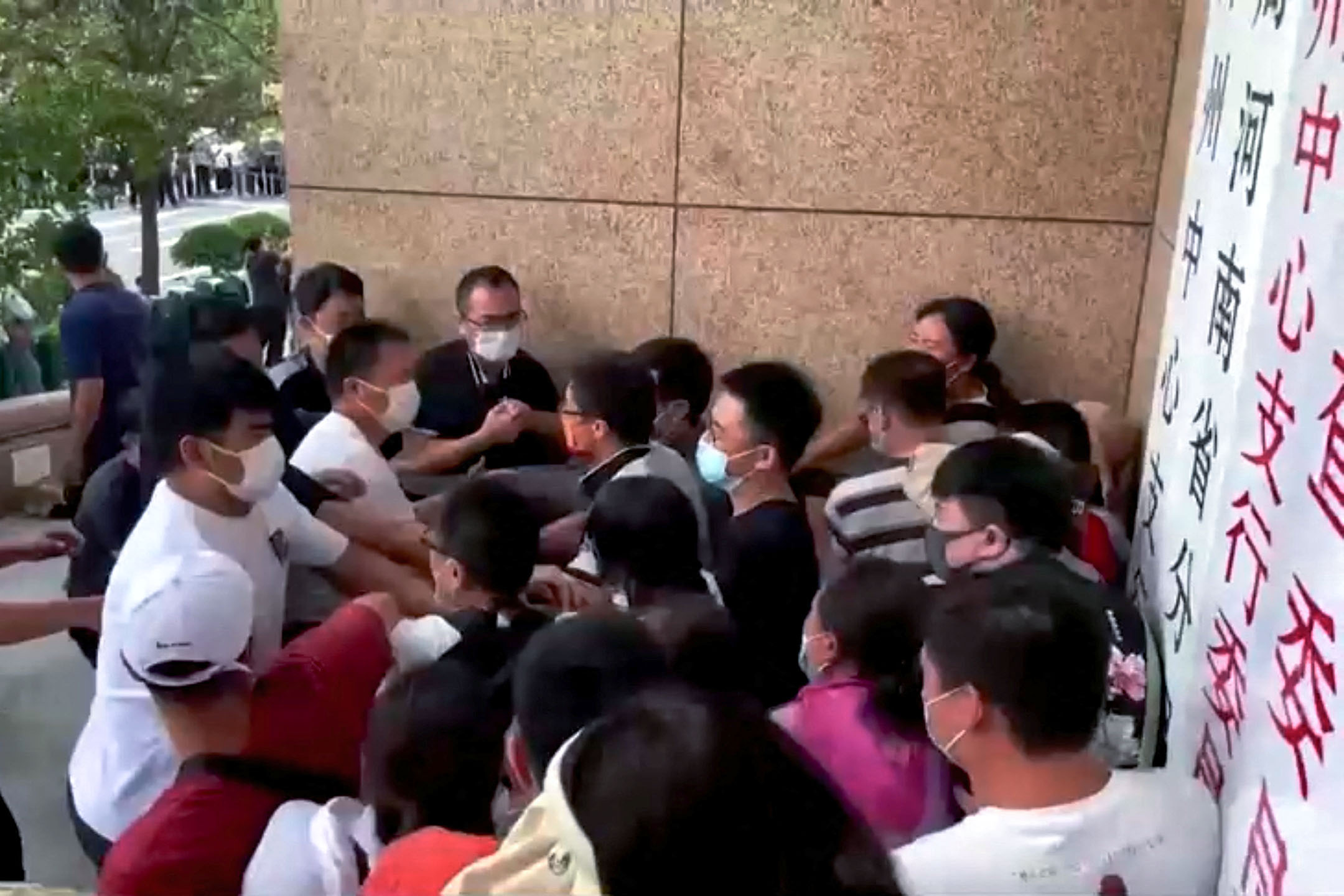 2022年7月10日,河南省郑州市中国人民银行大楼外,村镇银行储户抗议时,便衣保安人员与示威者发生冲突。