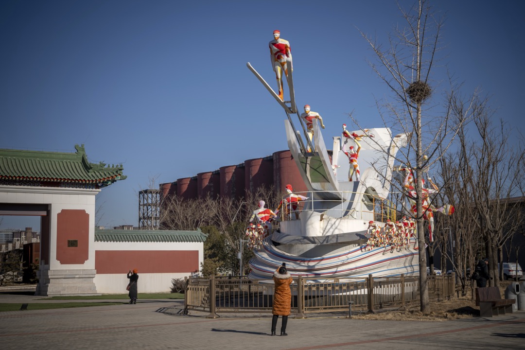 2022年1月,中国北京,一名游客在首钢改建成的冬奥大跳台项目比赛场地外拍照。