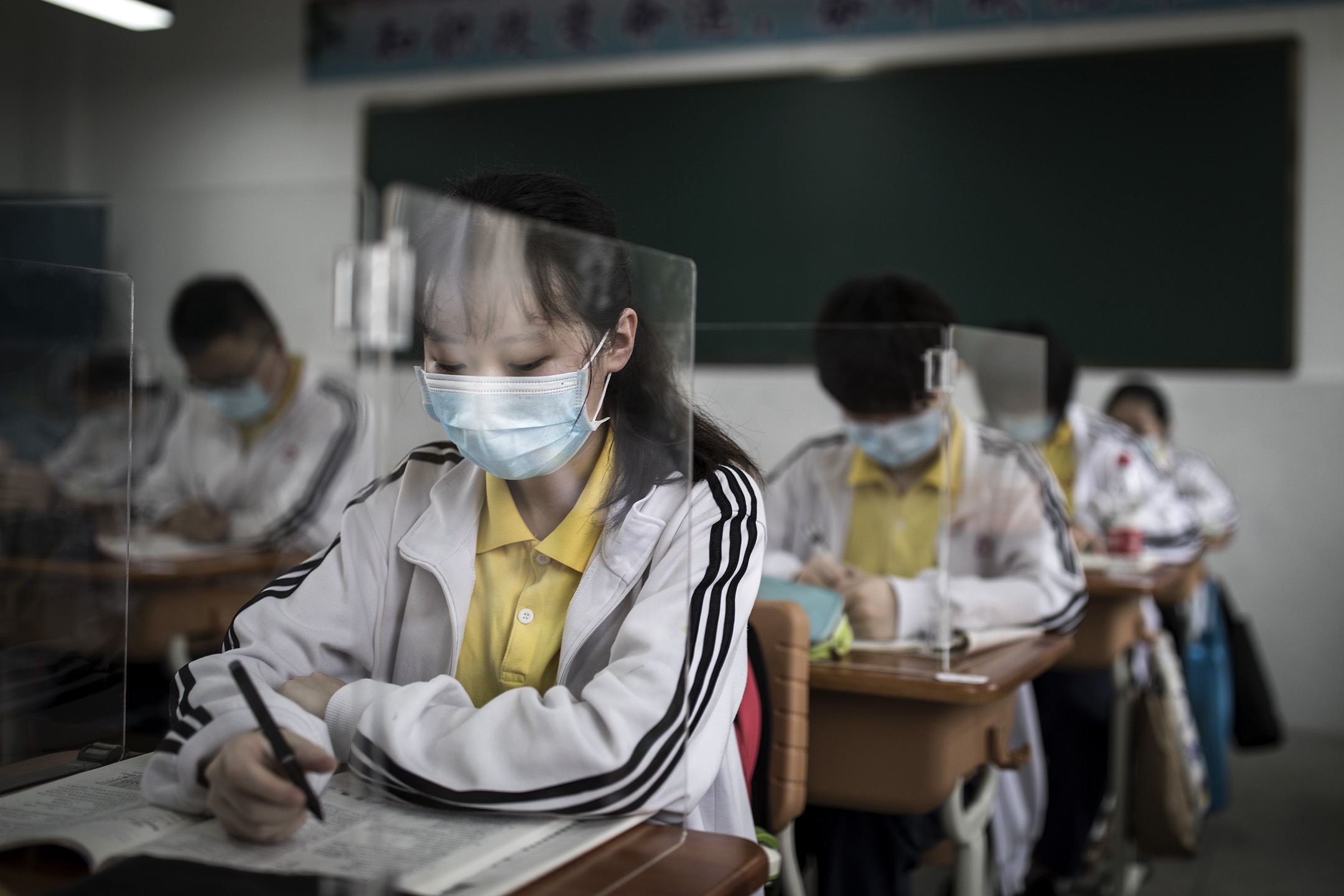 2020年5月,中国武汉,疫情缓和后学校逐渐复课,校方用胶板围起书桌预防病毒传播。