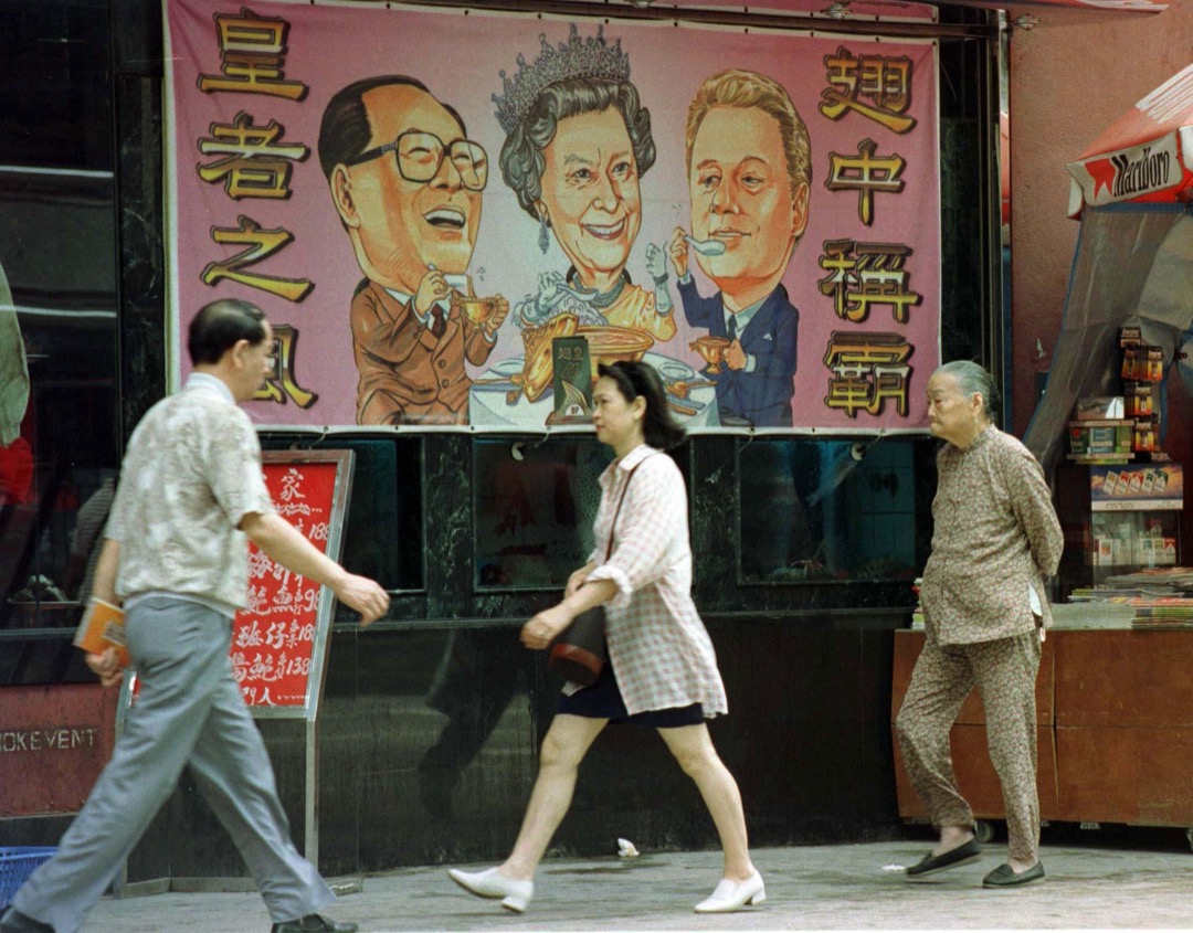 1997年6月26日,香港,一幅海鲜酒家的广告海报显示英女王伊莉莎白二世与中国国家主席江泽民、美国总统克林顿一齐吃鱼翅。