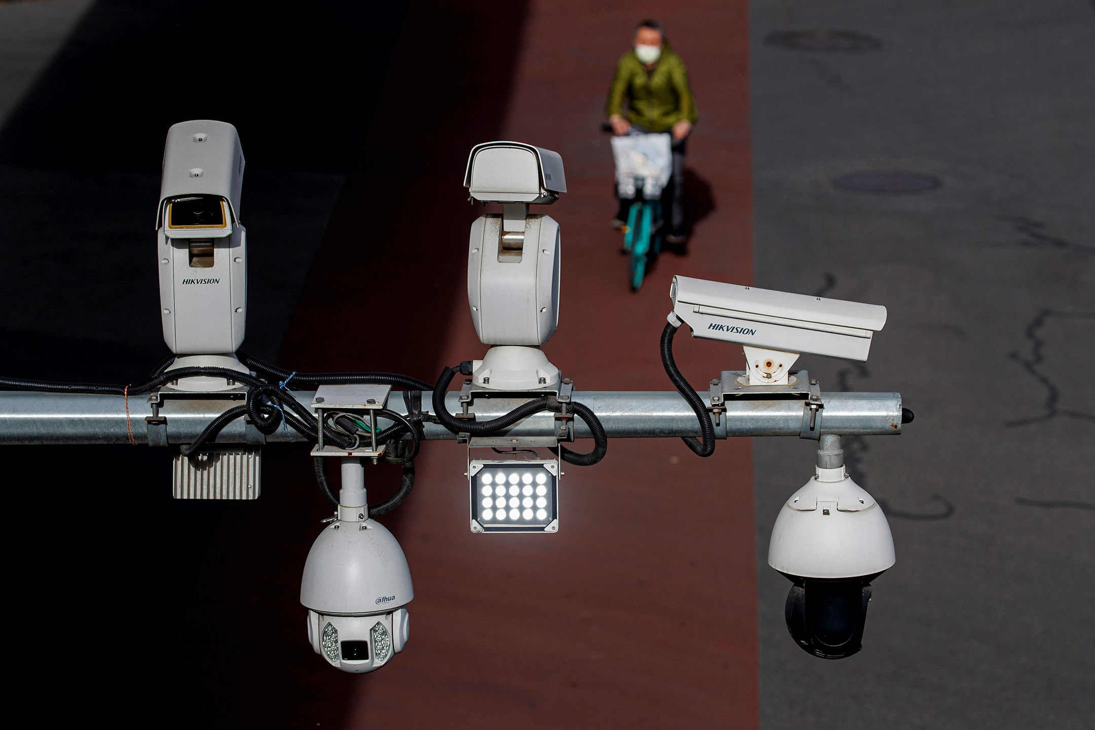 2020年5月11日，北京，一名男子騎車經過街道上的閉路電視。