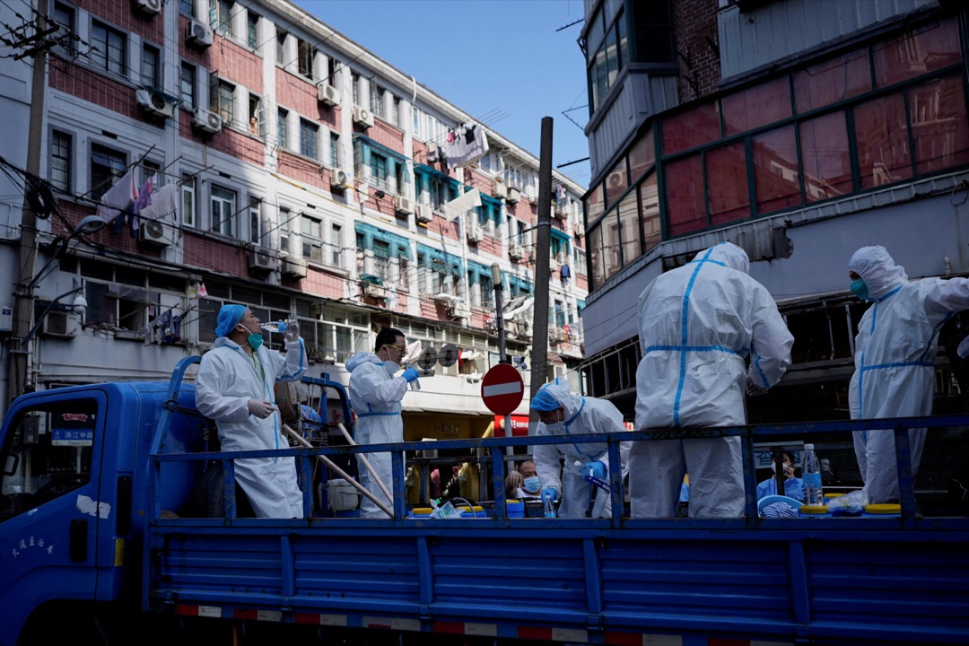2022年5月31日，中國上海，封城期間，穿保護衣的防疫人員在一輛貨車上休息。