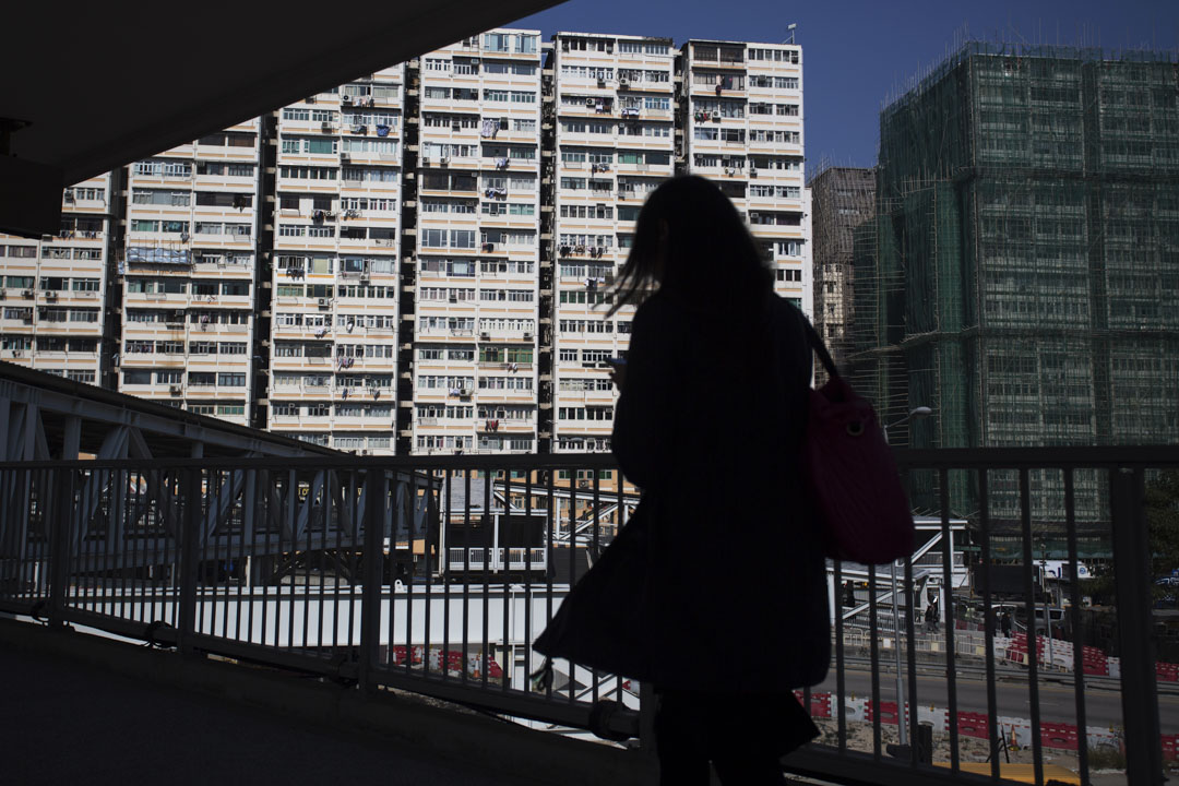 一名女士在西九龍住宅附近的行人天橋上行走。
