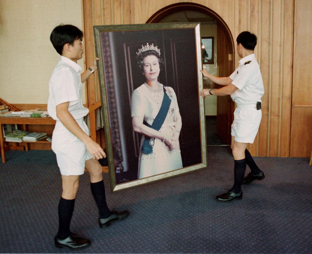 1997年6月17日,香港,工作人员从中环威尔斯亲王军营移除一幅英女王伊莉莎白二世的肖像,为即将进行的主权移交仪式作准备。