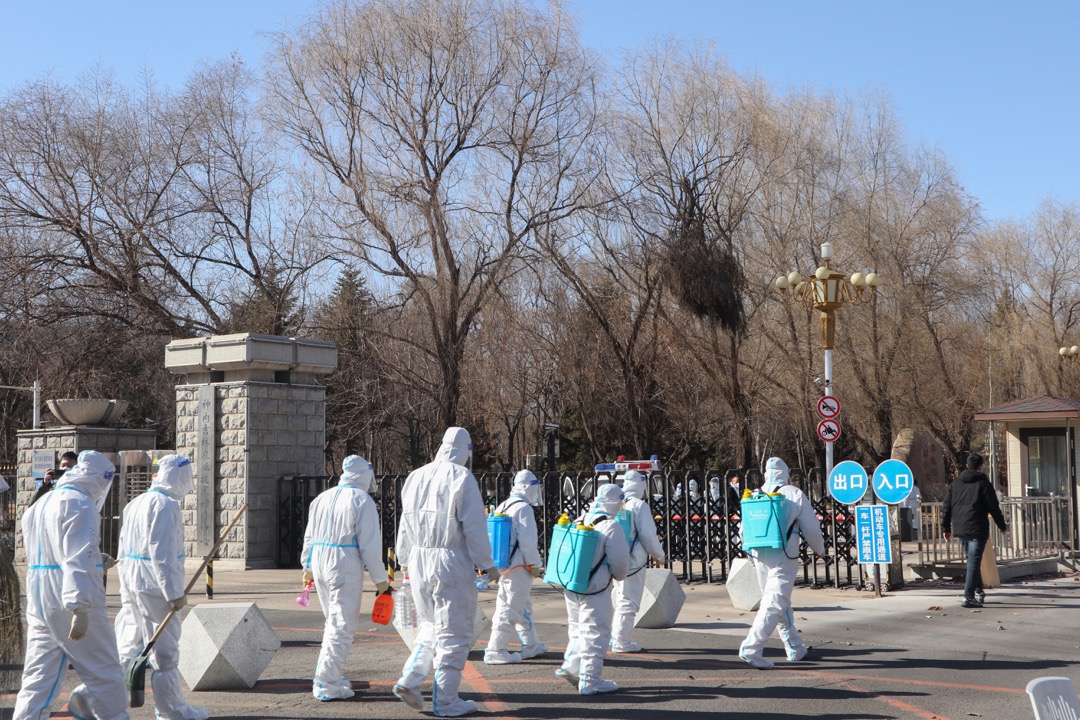 2022年3月11日,中國吉林,穿保護衣的工作人員到吉林農業科技學院進行消毒工作。