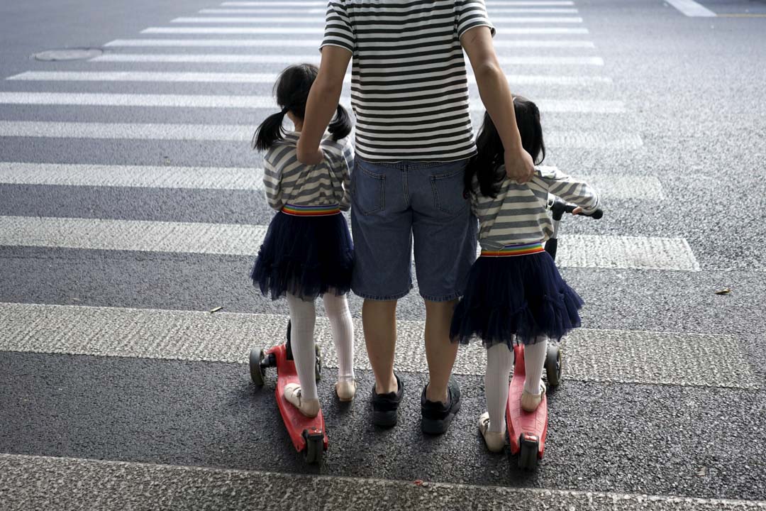 一位父親與他的女兒在上海過馬路。