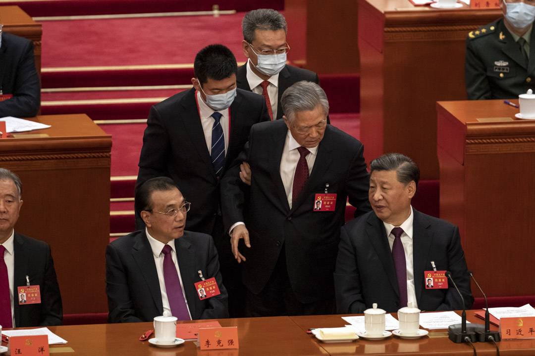 2022年10月22日,中国北京人民大会堂,中共前总书记胡锦涛在中国共产党第二十次全国代表大会闭幕会议离场,并与中国国家主席习近平讲话。图:Bloomberg via Getty Images