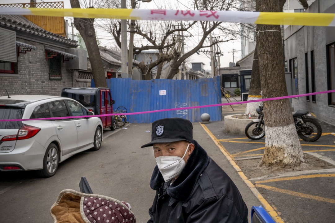 2022年3月25日,中国北京,一名保安员在一个被围封的小区外看守。