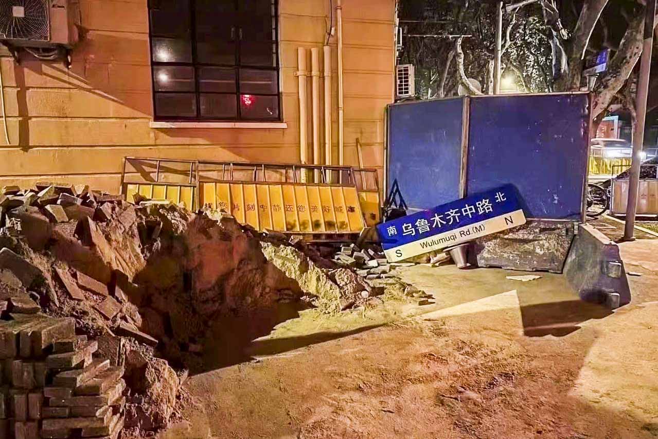 2022年11月27日，曾聚集大量悼念市民的上海烏魯木齊中路，路牌被拆掉放在地上。