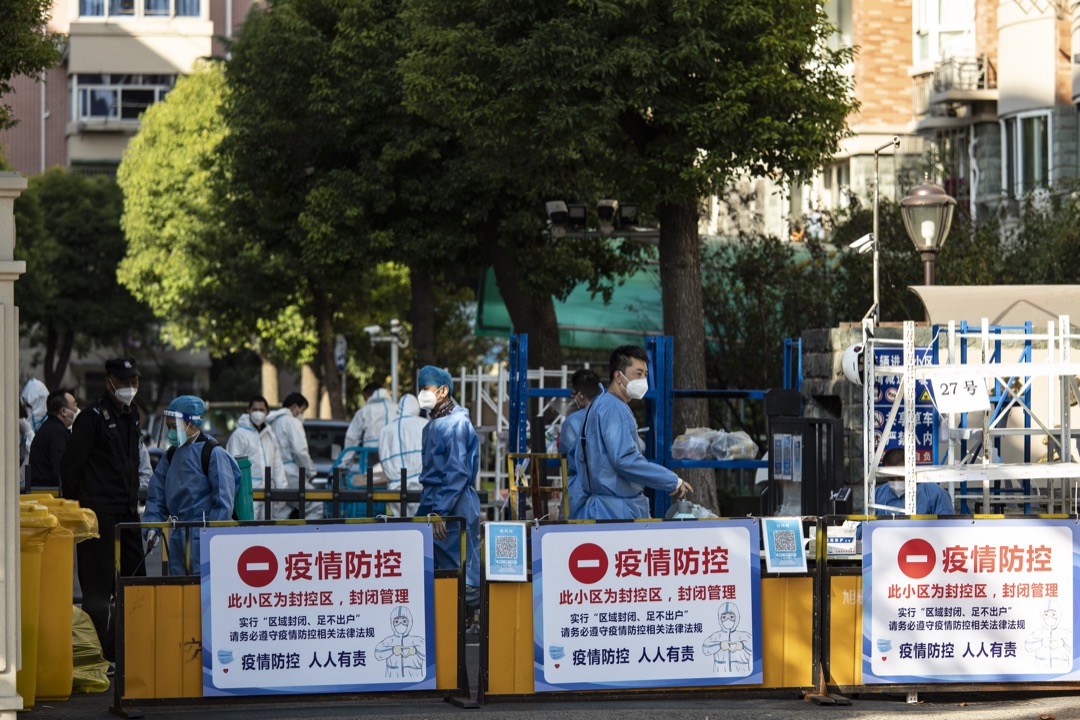 2022年11月7日,中國上海,一個被封鎖的小區的入口,有穿保護衣的工作人員在看守。