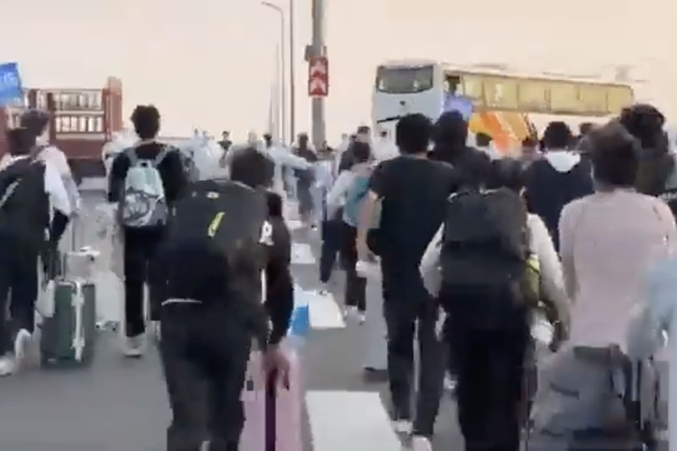 中國河南鄭州,大批富士康員工在防疫人員的安排下前往乘坐穿梭巴士離開廠區。