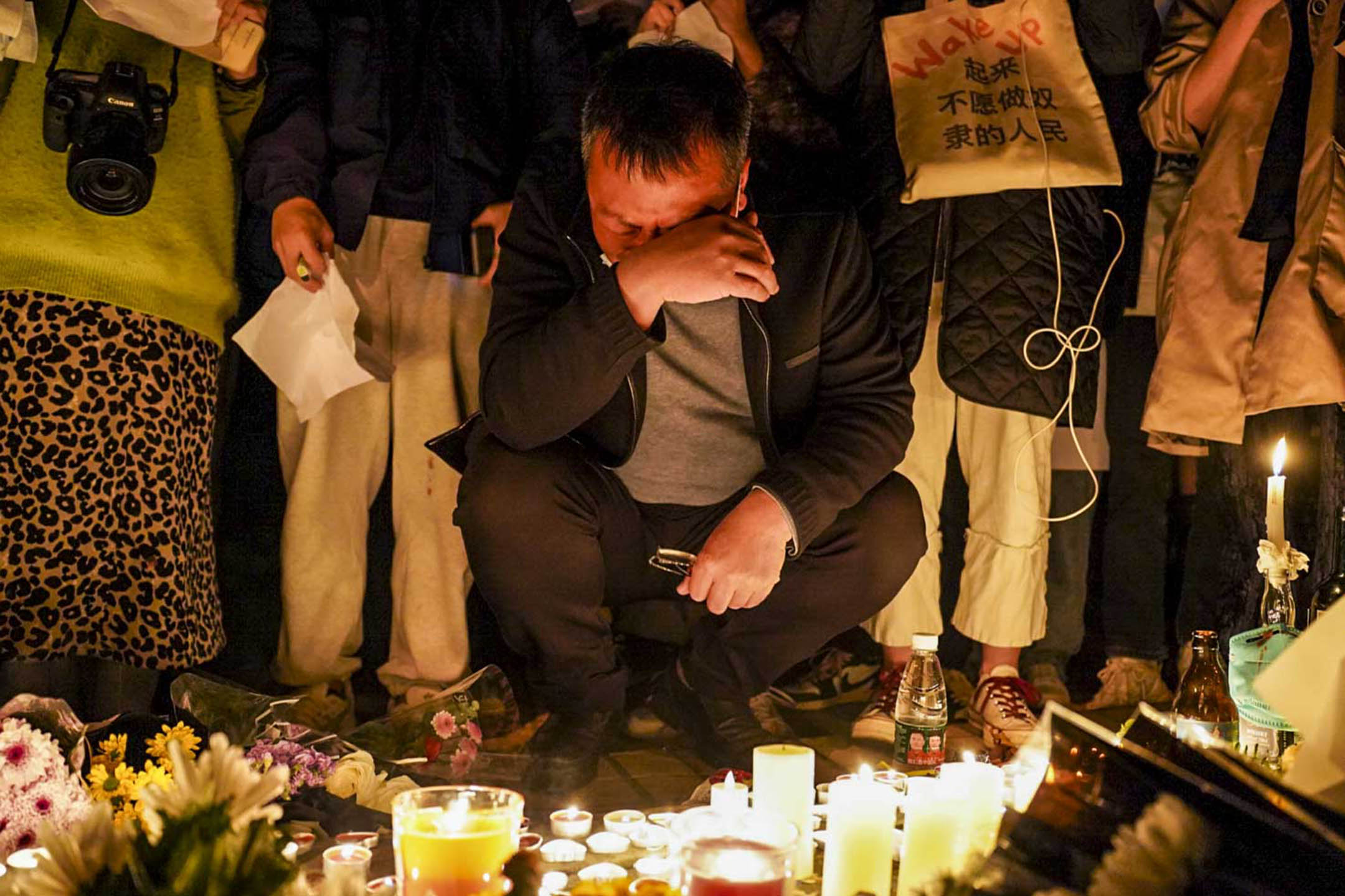 2022年11月26日深夜,上海烏魯木齊中路聚集大量市民,悼念11.24烏魯木齊火災10位逝者。