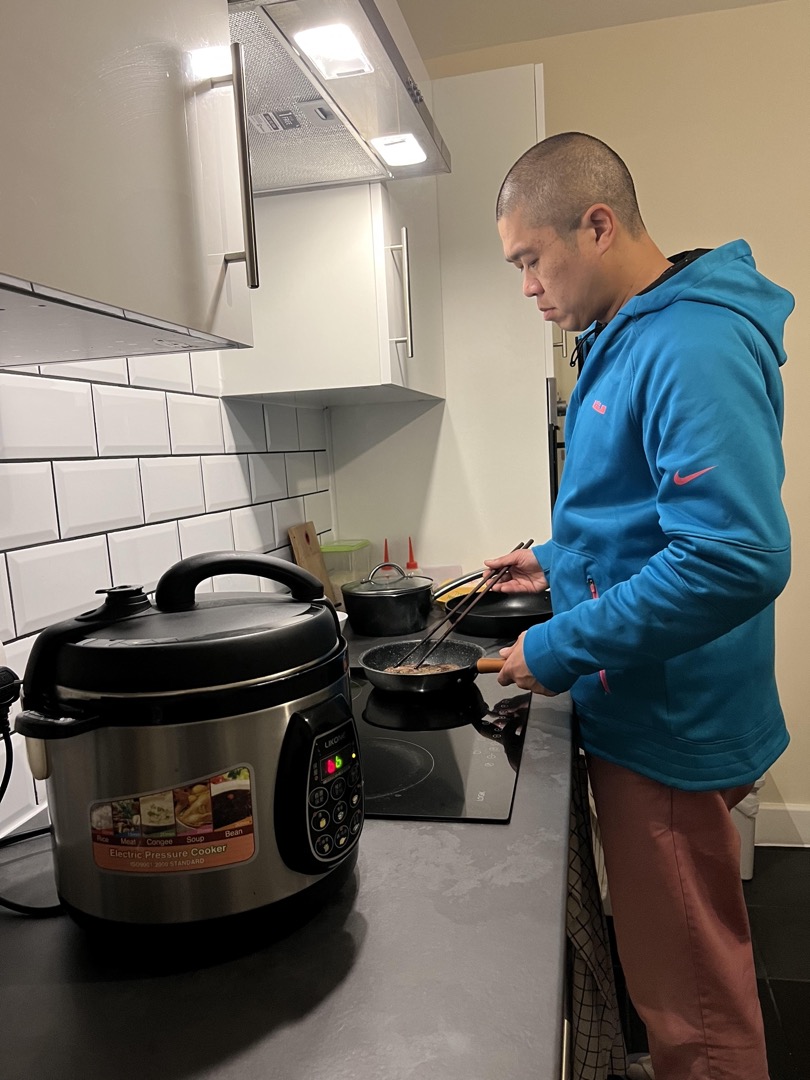阿庭丈夫阿傑在英國的家裏用電磁爐煮食。
