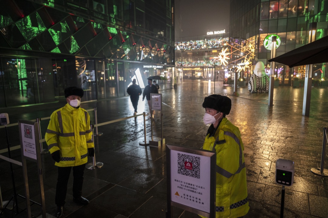 2022年11月20日,中國北京,兩名保安員在一個購物區外看守,進內的市民需要掃描「北京健康寶」二維碼。