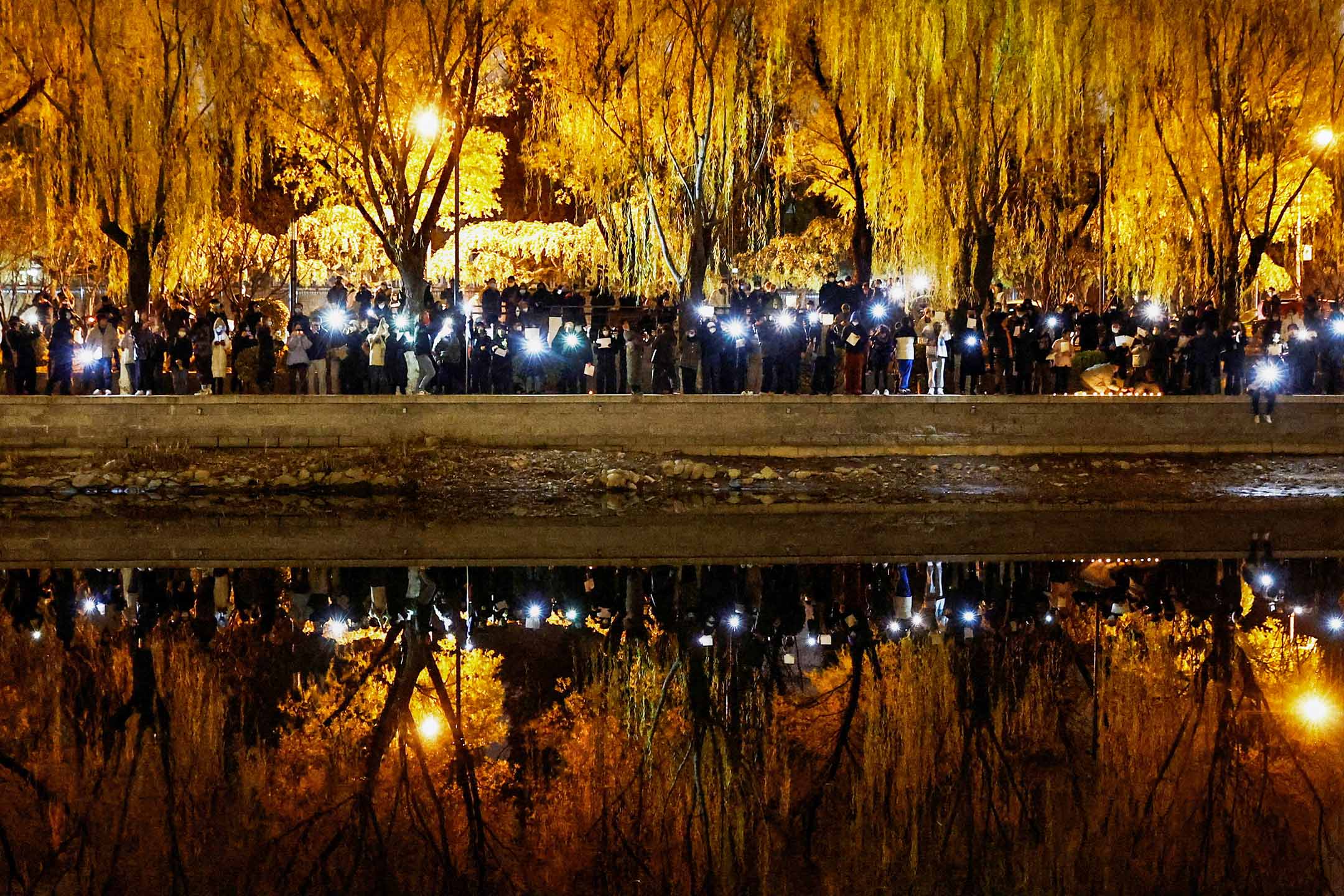 2022年11月27日,北京,人們聚集在一起守夜並舉著白紙抗議政府防疫政策,同時紀念烏魯木齊火災中的遇難者。