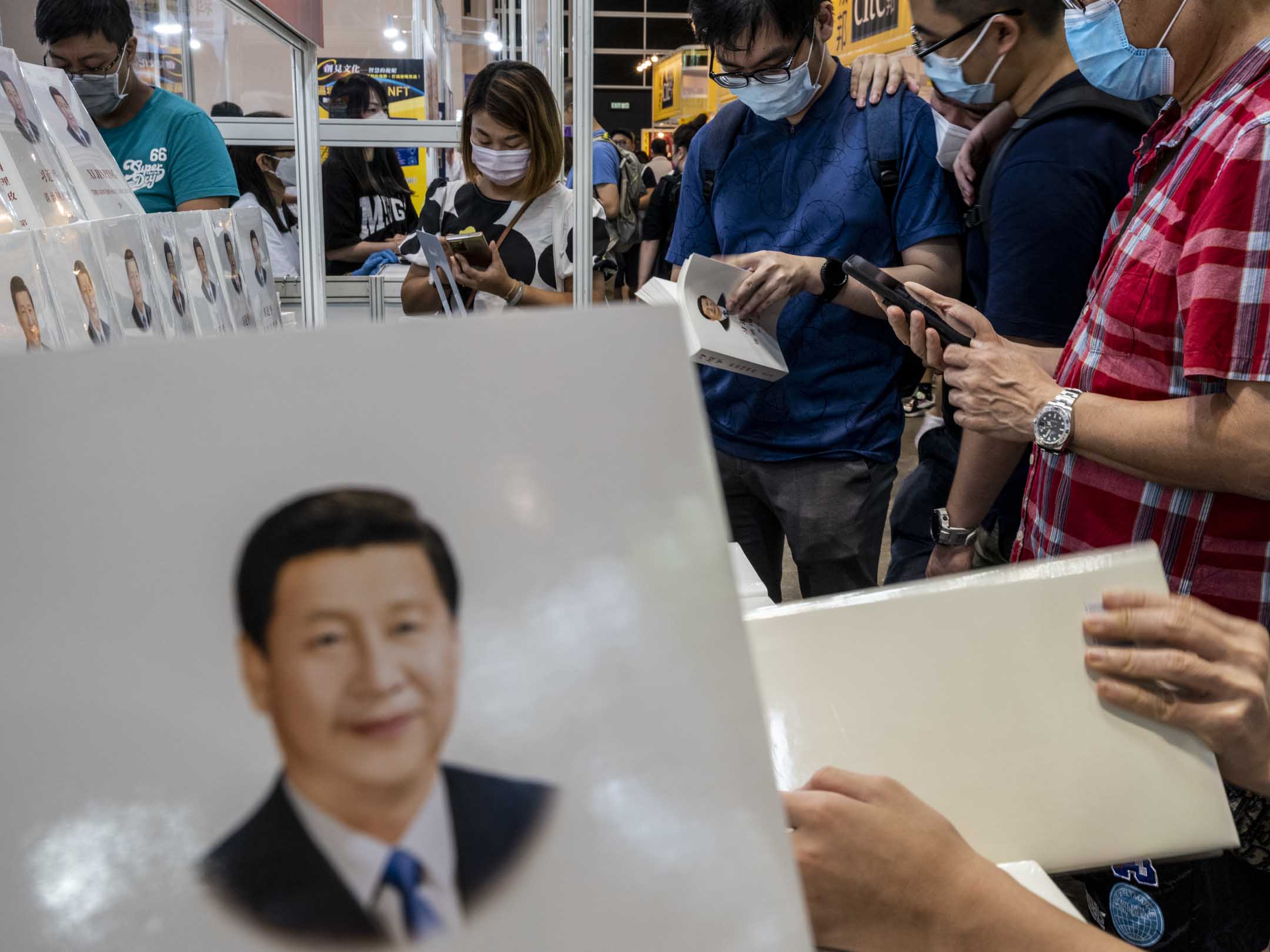 2022年7月22日,香港书展有不少书商都在宣传架上摆放了《习近平谈治国理政》,市民站著在档位阅读。