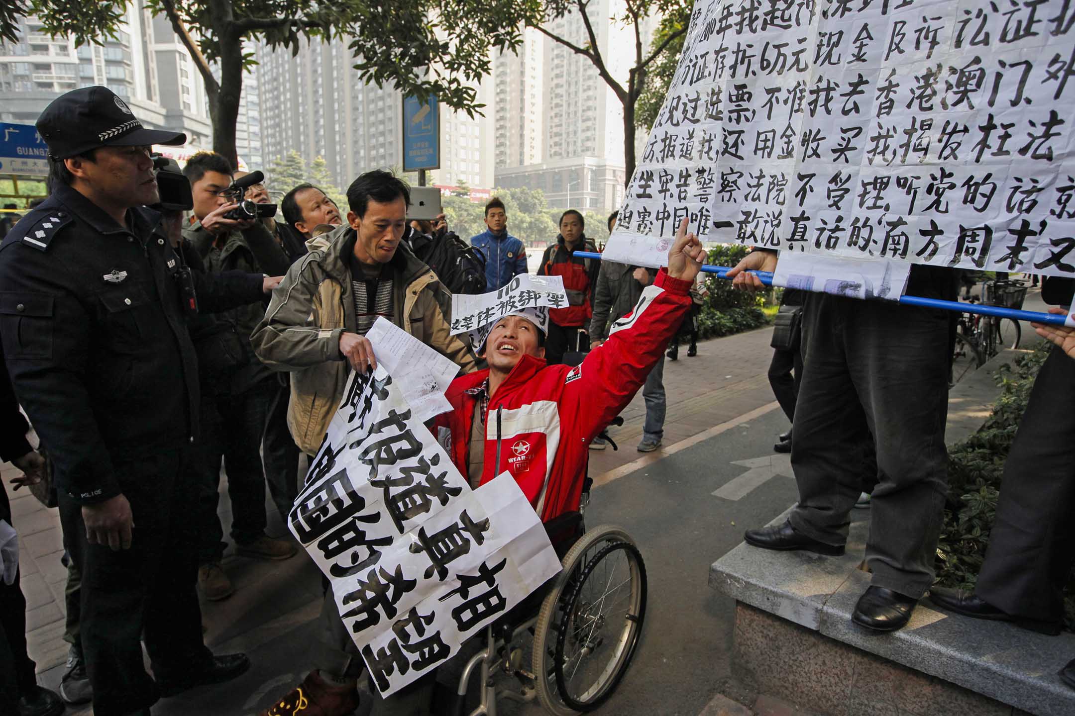 2013年1月10日，廣州，一名坐在輪椅上的《南方周末》支持者，在《南方周末》辦公室附近抗議被警察帶走。